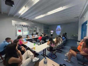 Taller de salud articular y fisioterapia en Hemojuve 2026 Ponencia en el aula, con el fisioterapeuta Rubén cuesta, comentando una imagen de una articulación en la pantalla